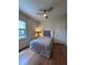 This bright bedroom boasts wood floors, ceiling fan, and a window providing natural light and neighborhood views at 8405 Adalina Pl, Orlando, FL 32827