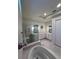 Luxurious bathroom featuring a soaking tub, a glass-enclosed shower, and a dual vanity for a spa-like experience at 8405 Adalina Pl, Orlando, FL 32827