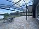 Expansive patio with pavers and large screened-in lanai, perfect for outdoor dining and entertaining with pond views at 8405 Adalina Pl, Orlando, FL 32827