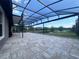 Large paved patio featuring an open-air screened lanai, ideal for enjoying outdoor living with a serene backyard view at 8405 Adalina Pl, Orlando, FL 32827