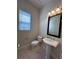 This powder room features a pedestal sink, classic fixtures, and natural light from a large window at 8405 Adalina Pl, Orlando, FL 32827