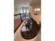 Elegant spiral staircase with dark wood treads and decorative iron railing leads to an open second floor at 8405 Adalina Pl, Orlando, FL 32827