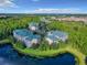 Aerial view of the condos surrounded by lush greenery and a tranquil lake, showcasing a serene residential environment at 9061 Treasure Trove Ln # 403, Kissimmee, FL 34747