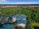 The condo building, showcasing the spacious community surrounded by lush greenery and a parking area, offers a serene living environment at 9061 Treasure Trove Ln # 403, Kissimmee, FL 34747