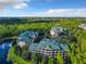 Aerial view showing the condos nestled within a lush, green landscape, with ample parking and scenic water views at 9061 Treasure Trove Ln # 403, Kissimmee, FL 34747