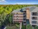 Exterior view of building with multiple levels of balconies and staircases, surrounded by trees and greenery at 9061 Treasure Trove Ln # 403, Kissimmee, FL 34747