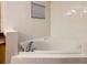 Bright bathroom featuring a tiled triangular soaking tub and window with blinds at 9061 Treasure Trove Ln # 403, Kissimmee, FL 34747
