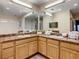Bright bathroom with double sinks, generous counter space, and wooden cabinets at 9061 Treasure Trove Ln # 403, Kissimmee, FL 34747