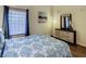 Inviting bedroom features wood-look floors, a large window, and dresser with mirror at 9061 Treasure Trove Ln # 403, Kissimmee, FL 34747