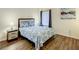 Cozy bedroom features hardwood floors, a queen bed, a nightstand with a lamp, and a window with blinds at 9061 Treasure Trove Ln # 403, Kissimmee, FL 34747