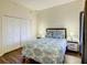 Comfortable bedroom with a closet, nightstands with lamps, queen bed with bright comforter and wood laminate flooring at 9061 Treasure Trove Ln # 403, Kissimmee, FL 34747