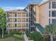 Close view of building with stairs, multiple balconies, and lush tropical landscaping surrounding property at 9061 Treasure Trove Ln # 403, Kissimmee, FL 34747