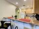 Kitchen featuring a breakfast bar with granite countertops and natural wood cabinets at 9061 Treasure Trove Ln # 403, Kissimmee, FL 34747