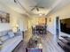 Open-concept living area featuring modern furnishings and wood flooring, flowing to dining and kitchen at 9061 Treasure Trove Ln # 403, Kissimmee, FL 34747