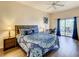 Lovely bedroom with hardwood flooring, fan, desk, and slider to a balcony for relaxation and work at 9061 Treasure Trove Ln # 403, Kissimmee, FL 34747