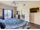 Spacious bedroom with hardwood floors, ceiling fan, and direct access to a private balcony with outdoor seating at 9061 Treasure Trove Ln # 403, Kissimmee, FL 34747