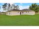 Spacious backyard with lush green grass, with the back exterior of the home visible at 927 Cambridge Ct, Kissimmee, FL 34758