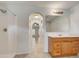 Bright bathroom featuring a shower, vanity with wooden cabinets, mirror, and archway to the main living area at 927 Cambridge Ct, Kissimmee, FL 34758