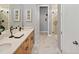 Bathroom featuring a double vanity, marble countertops, framed mirrors, and a tiled walk-in shower at 9560 Archway Aly, Orlando, FL 32832
