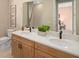 Bright bathroom featuring double sinks, wooden cabinets, a large mirror, and a view into an adjacent bedroom at 9560 Archway Aly, Orlando, FL 32832