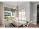 Dining area with natural light, features a rustic wooden table and modern chandelier at 9560 Archway Aly, Orlando, FL 32832