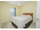 Bedroom with wood headboard and neutral bedding, complemented by a ceiling fan at 9635 Fenrose Ter, Orlando, FL 32827