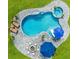 Aerial view of a backyard featuring a pool, spa, lounge chairs, and a fire pit on a paved patio at 9877 Laurel Berry Dr, Orlando, FL 32827