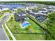 Aerial view of the spacious backyard featuring a sparkling pool, lush landscaping, and a serene lake view community at 9877 Laurel Berry Dr, Orlando, FL 32827