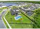 Aerial view of a backyard featuring a pool, spa, outdoor seating, and manicured lawn in a suburban neighborhood at 9877 Laurel Berry Dr, Orlando, FL 32827