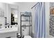 Well-organized bathroom with modern sink, toilet, and shower, featuring a blue shower curtain at 9877 Laurel Berry Dr, Orlando, FL 32827