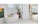Modern bathroom with a freestanding tub and decorative wallpaper at 9877 Laurel Berry Dr, Orlando, FL 32827