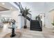 Elegant entryway with a dark staircase, stylish lighting, and views into the living and dining areas at 9877 Laurel Berry Dr, Orlando, FL 32827