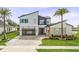 Striking modern home boasts clean lines, a glass garage door, and professional landscaping at 9877 Laurel Berry Dr, Orlando, FL 32827