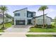 Modern two-story home with a glass garage door, geometric architecture, and meticulously landscaped yard at 9877 Laurel Berry Dr, Orlando, FL 32827