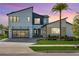 Contemporary two-story home featuring a glass garage door, modern design, and colorful sunset sky at 9877 Laurel Berry Dr, Orlando, FL 32827