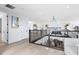 Bright hallway with blonde wood floors, modern railing, and open view to the living room at 9877 Laurel Berry Dr, Orlando, FL 32827