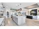 Open kitchen with large island, stainless appliances, and light wood flooring at 9877 Laurel Berry Dr, Orlando, FL 32827