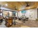 Cozy outdoor living area featuring a bar, TV, seating area, and serene backyard views at 9877 Laurel Berry Dr, Orlando, FL 32827