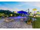 Relaxing backyard oasis featuring a custom pool, lounge seating, mature tropical landscaping, and paver decking at 9877 Laurel Berry Dr, Orlando, FL 32827