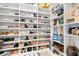 Luxurious walk-in closet with custom shelving for shoes and designer handbags, maximizing storage and style at 9877 Laurel Berry Dr, Orlando, FL 32827