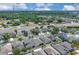 A neighborhood aerial view features well-maintained homes with mature trees lining a street near a pond and highway at 9931 Cypress Knee Cir, Orlando, FL 32825