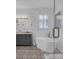 Bright bathroom showcasing a soaking tub, updated vanity, and modern glass shower at 9931 Cypress Knee Cir, Orlando, FL 32825
