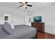 Bedroom featuring a ceiling fan, wood floors, and a dresser with a television at 9931 Cypress Knee Cir, Orlando, FL 32825