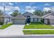 Attractive single-story home with a well-maintained lawn, gray paint, and a two-car garage in a suburban neighborhood at 9931 Cypress Knee Cir, Orlando, FL 32825