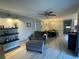Inviting living room with wood-style tile, comfortable furniture, and stylish decor, with dining area beyond at 1001 Arden St, Longwood, FL 32750