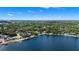 Scenic aerial view of waterfront homes lining the lake with lush trees and blue skies at 101 E Lauren Ct, Fern Park, FL 32730