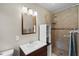 This bathroom features a tiled walk-in shower, a vanity, and a decorative mirror with modern lighting at 101 E Lauren Ct, Fern Park, FL 32730
