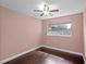 This bedroom features hardwood floors, a ceiling fan, and a bright window offering ample natural light at 101 E Lauren Ct, Fern Park, FL 32730