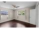 This bedroom features hardwood floors, a ceiling fan, and two bright windows offering ample natural light at 101 E Lauren Ct, Fern Park, FL 32730