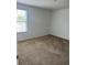 Spacious bedroom with a large window, carpeted floors, and neutral walls at 10128 Hartford Maroon Rd, Orlando, FL 32827